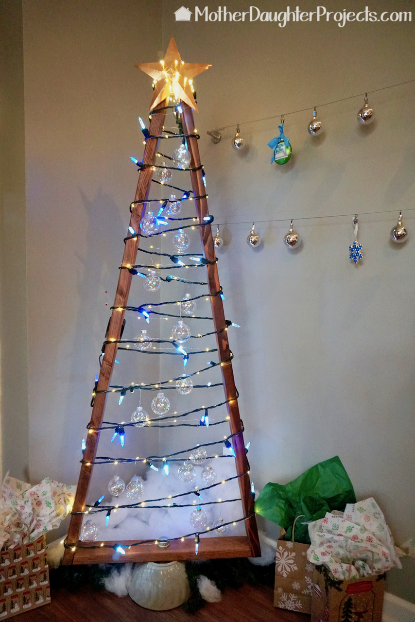 Learn how to use simple 2x4 wood to make this modern and rustic Christmas tree for the holidays. Great for smart Christmas lights, fairy lights and more! All complete with a quikete concrete base.