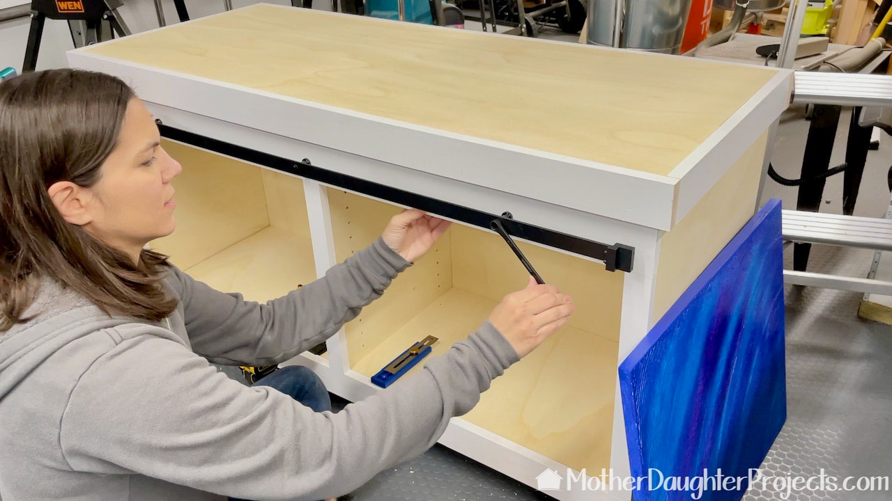 Attaching the sliding door hardware to the face frame. 