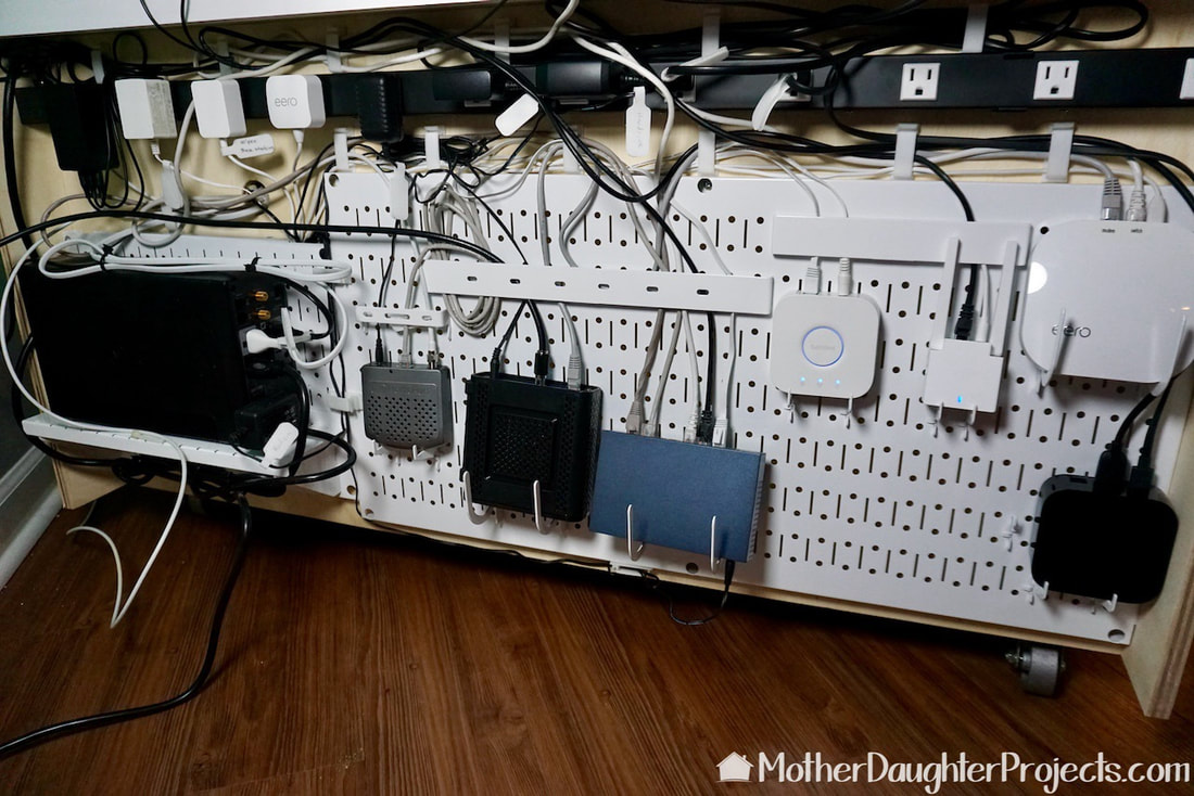 Cable management at its best! That's a battery backup on the shelf and a multi-outlet power strip at the top. The Wall Control bars help keep the cables in place.