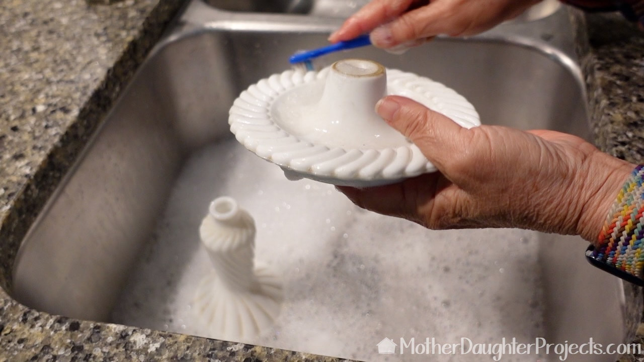 Wash milk glass lamp parts in the sink with Dawn.